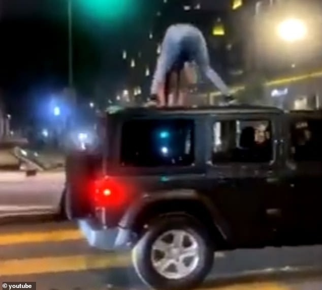 Scary moment woman twerking on the roof of a Jeep gets dropped on her head during downtown Los