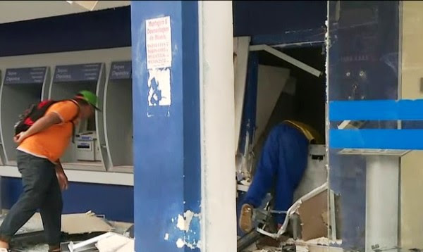 Pessoas pegam dinheiro após explosão de caixas eletrônicos (Foto: Reprodução/TV Globo)