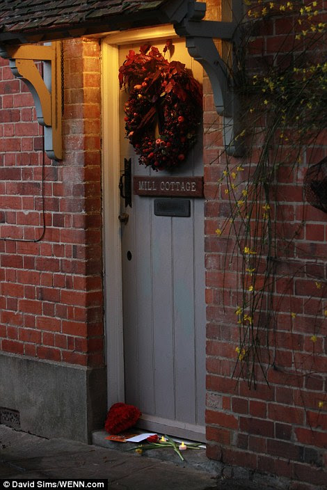 Fans have put flowers outside the cottage home where the singer was found dead by a friend yesterday