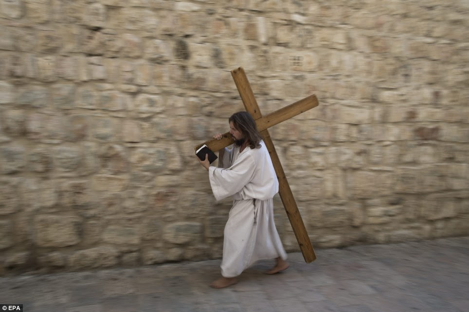 Carrying his cross: James Joseph carries a cross at the Via Dolorosa ninth station at the Old City of Jerusalem as he explores the life and path of Jesus Christ