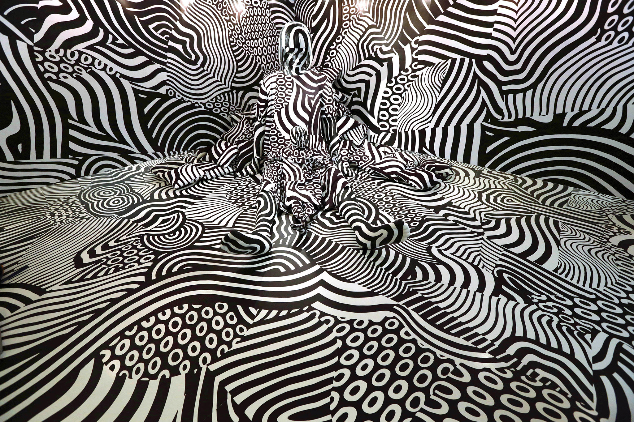 Model feebee poses as part of art installation "Narcissism : Dazzle room" made by artist Shigeki Matsuyama at rooms33 fashion and design exhibition in Tokyo, Wednesday, Sept. 14, 2016. Matsuyama's installation features a strong contrast of black and white, which he learned from dazzle camouflage used mainly in World War I. (AP Photo/Eugene Hoshiko)