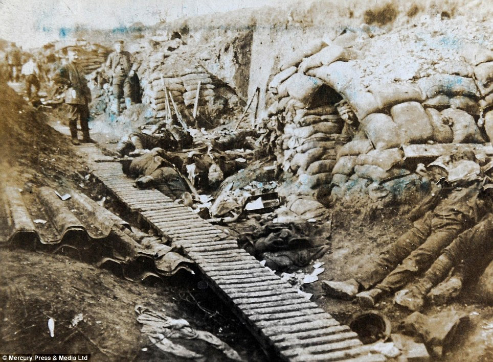 Horrifying: This salvaged image shows the terrible conditions from the First World War, where this trench is strewn with bodies and rubbish while servicemen watch on