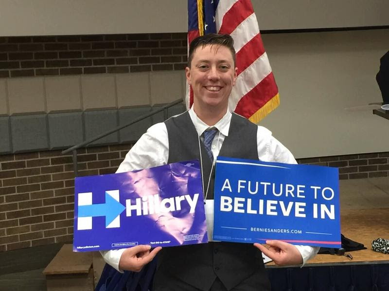 Jack Schuler poses with both Sanders and Clinton signs.