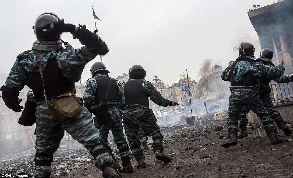 Pitched battle: Berkut riot police throw stones at anti-government protesters, who  threw rocks in retaliation