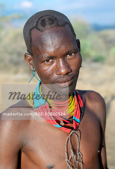A Hamar man with an unusual hairstyle attends a Jumping of the Bull ceremony.The semi nomadic Hamar of Southwest Ethiopia embrace an age grade system that includes several rites of passage for young men.The most elaborate of them and the most important is the Jumping of the Bull ceremony. Stock Photo - Rights-Managed, Artist: AWL Images, Code: 862-03820524