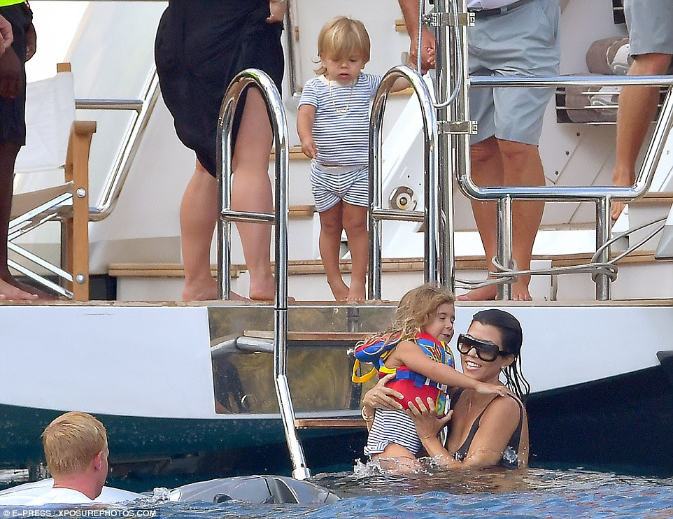 Water babies: The four-year-old kept a grip on her mom as she ventured into the water