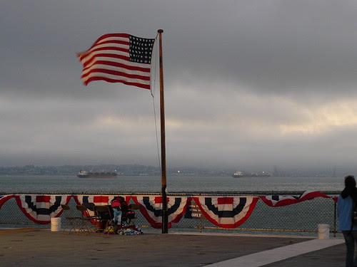 At the stern end of the flight deck, a remembered flag flaps in the breeze At the stern end of the flight deck, a remembered flag flaps in the breeze