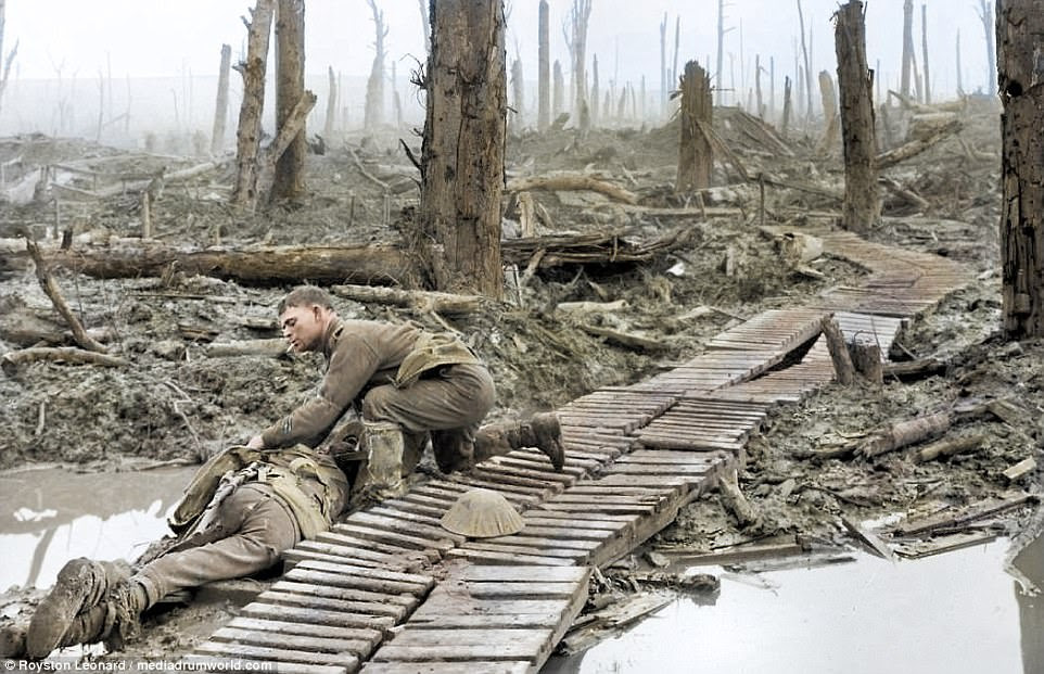 A soldier smokes  a cigarette as he appears to tend a dead or injured fighter on a roughly hewn makeshift bridge across a muddy river. Fought between July 1 and November 1, 1916, near the Somme River in France, the Battle of the Somme was one of the bloodiest military battles in history. On the first day alone, the British suffered more than 57,000 casualties, and by the end of the campaign the Allies and Central Powers would lose more than 1.5 million men