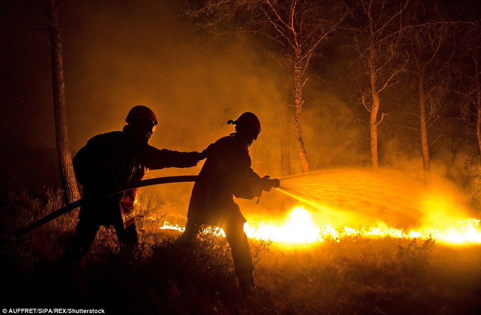 Como a escuridão caiu ontem à noite os bombeiros continuaram a mangueira para baixo áreas de floresta em um esforço para evitar que o fogo se espalhando