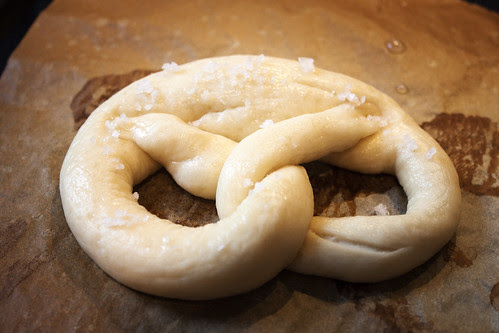 bayrische Breze vor dem Backen mit Salz bestreuen