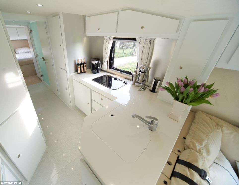 Stylish living: This bus boasts a slick white kitchen area with a large fridge freezer with plenty of room to store a range of expensive food and drinks