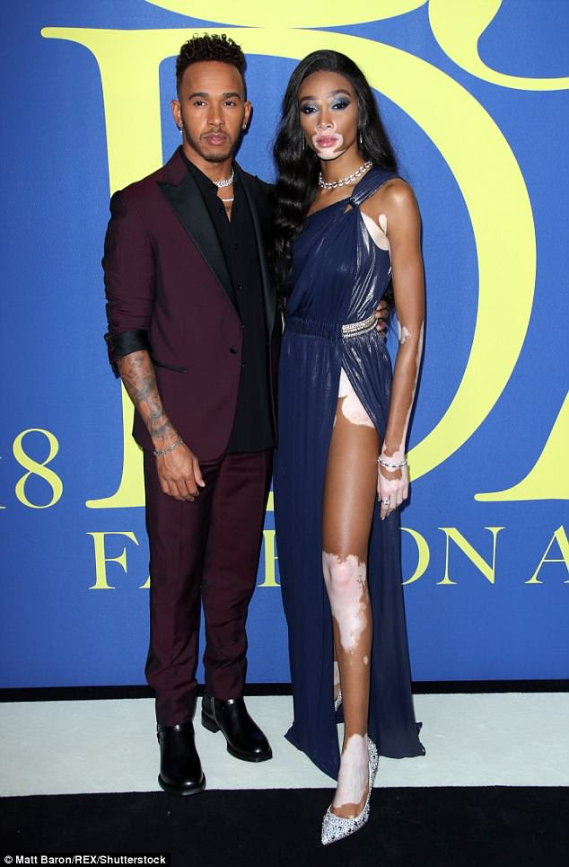Tonificado: Cinching em sua cintura esbelta, o vestido que flui em uma saia fluindo elegante com uma perigosa alta divisão, que brilhou pernas em tons do modelo