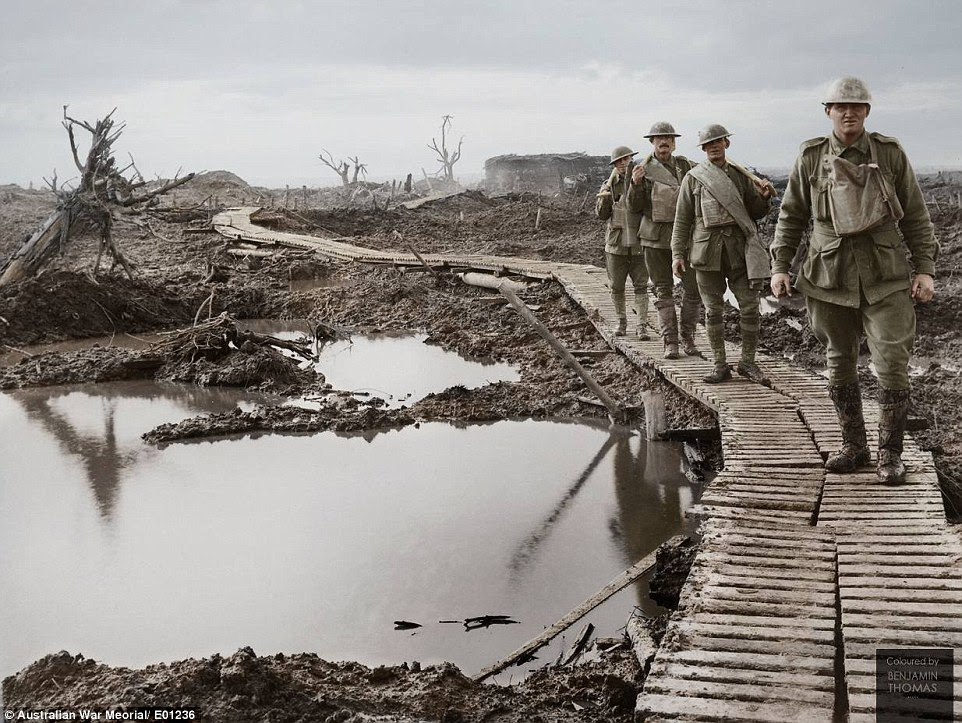 Four Australian soldiers walking along the duckboard track during the Third Battle of Ypres in September and October 1917