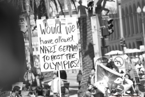 Protester with sign: Would we have allowed Nazi Germany to host the Olympics?