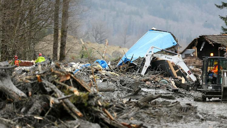 Workers dig through debris in the mudslide near Oso