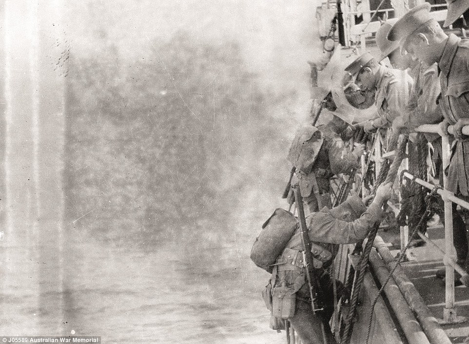 Troops clamber down rope ladders into boats to be taken ashore on the morning of the landing