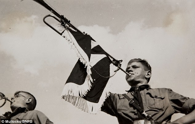 A member of the Hitler Youth pictured blowing a bugle