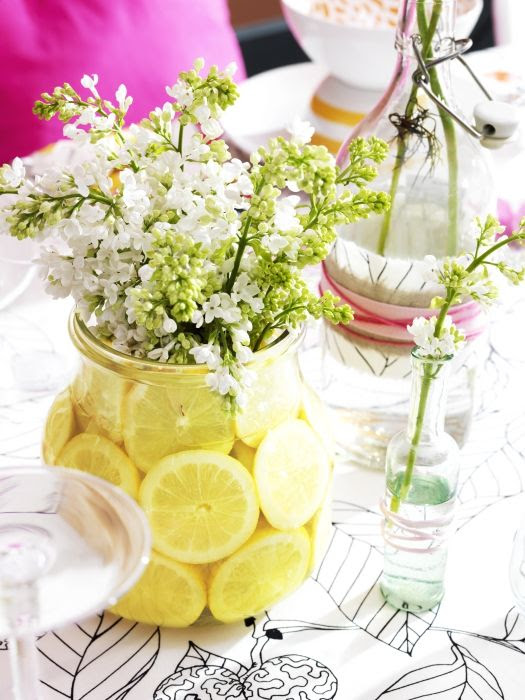 Fill clear glass ENSIDIG vases from IKEA with sliced lemons and sprays of flowers for fresh and inexpensive table decorations.