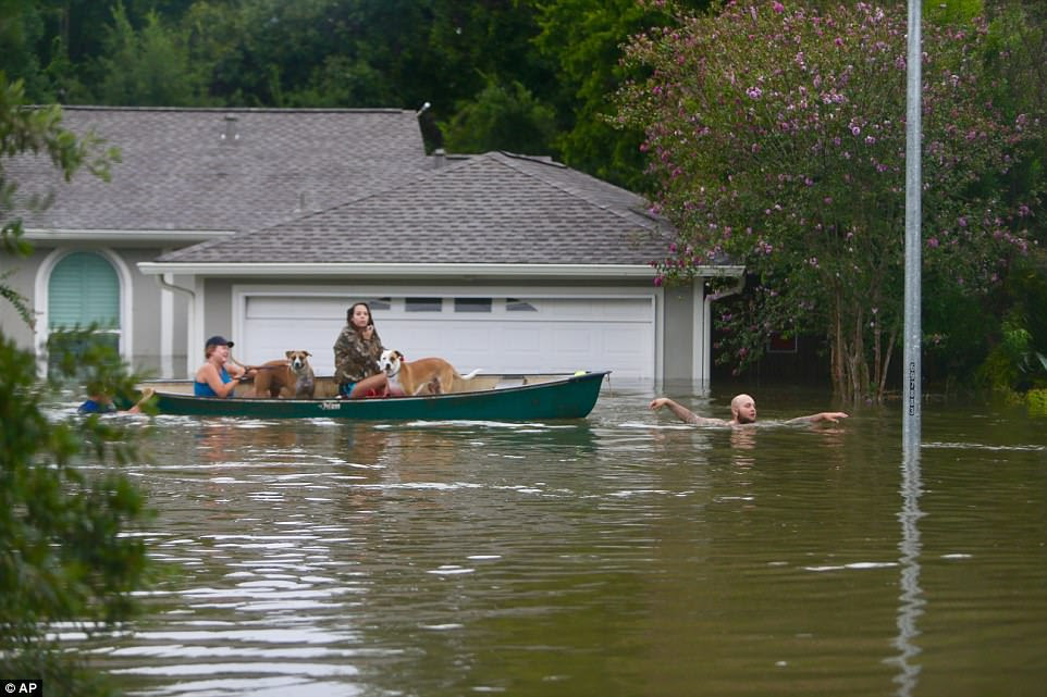 A family evacuates their Meyerland home in Houston. Rescuers answered hundreds of calls for help Sunday as floodwaters from the remnants of Hurricane Harvey rose high enough to begin filling second-story homes