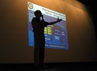 US Navy 040605-N-6633C-002 Commander Naval Reserve Force, Vice Adm. John G. Cotton, is silhouetted in front of a Powerpoint slide mapping out the Naval Reserve Force's future