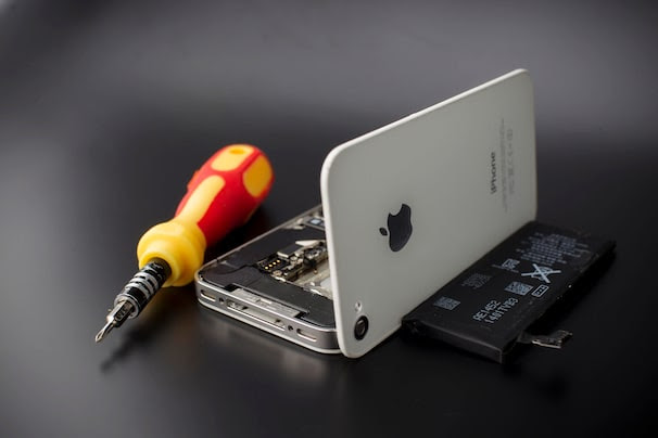 A smartphone sold as an Apple Inc. iPhone 4S, with its back cover and battery removed, is arranged for a photograph in Hong Kong, China, on Saturday, Jan. 11, 2014. Apple Inc.'s iOS smartphone operating system gained ground in the U.S. in the final quarter of 2013 as the share of the market served by the platforms of Google Inc., Microsoft Corp. and BlackBerry Ltd. shrank. Photographer: Brent Lewin/Bloomberg