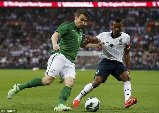 Getting shirty: England captain Ashley Cole sees his shirt pulled by Irleand's Seamus Coleman