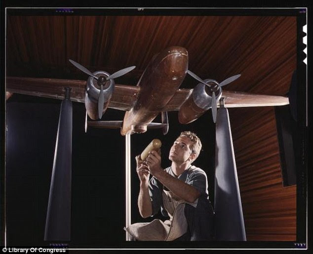 To scale: A model of the B-25 plane is put together for wind tunnel tests in Inglewood, California, with the maker holding a miniature version of the type of bomb the plane will carry (Alfred Palmer, October 1942)