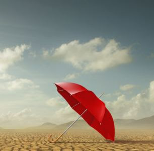Red umbrella in desert landscape