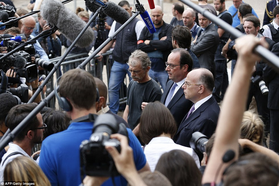 O presidente francês, François Hollande (centro) ladeado por Hubert Wulfranc prefeito de Saint-Etienne-du-Rouvray (esquerda) e ministro do Interior francês Bernard Cazeneuve (à direita), fala à imprensa como ele deixa a prefeitura do Saint-Etienne-du-Rouvray