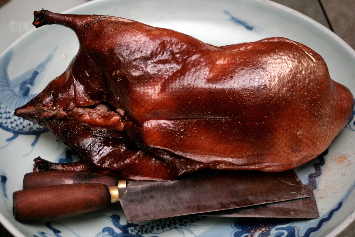 Signature wood-fire roasted duck in Peking style, dusted with gold for the festive season