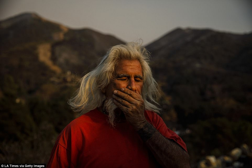 It's currently 45 per cent contained as more than 8,000 firefighters attempt to tackle it at a cost of $128million. Above Rusty Smith stands outside of his home in Flores Flats near Montecito as he appears shocked that it survived the blaze