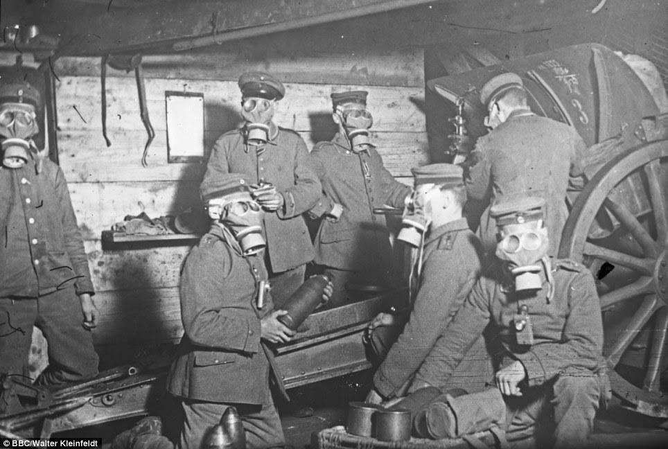 Constantly under threat: Gas attacks were a frequent menace in the Somme during the war so this group wear masks as they load shells into their gun in 1916