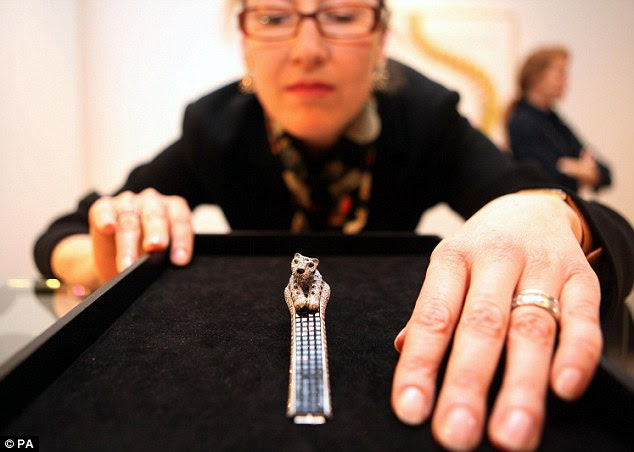 A Sotheby's employee admires the 1984 platinum, diamond and sapphire Panthere Cartier wristwatch valued at £99,350