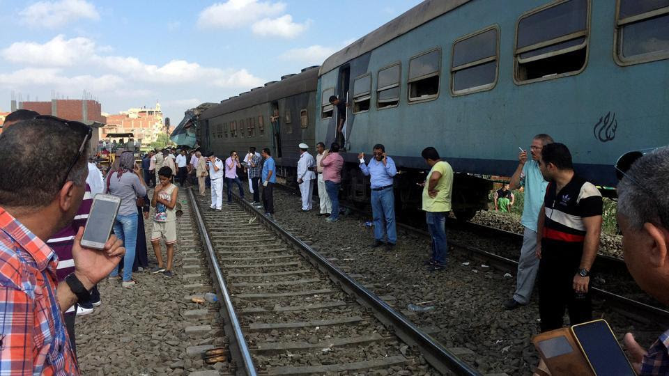 Egyptians look at the crash of two trains that collided near the Khorshid station in Egypt's coastal city of Alexandria, Egypt on Friday.