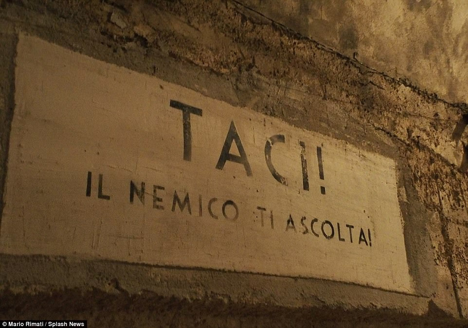 This notice painted on the brown concrete walls of the bunker orders passers-by to be quiet because 'the enemy are listening'. Nearly a thousand Nazis slept in the bunker after Italy's surrender and there were facilities including a restaurant and a theatre