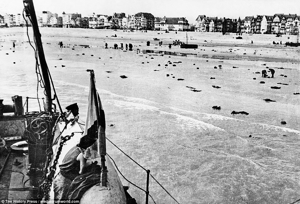 The last remaining soldiers prepare to leave Dunkirk after German forces took the British and French by surprise. Many bodies lay strewn on the beach as a rescue ship leaves the bay
