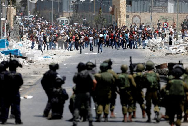 Palestinian protesters hurl stones at Israeli troops following a protest in support of Palestinian prisoners on hunger strike in Israeli jails, in the West Bank village of Beita, near Nablus May 19, 2017. REUTERS/Mohamad Torokman