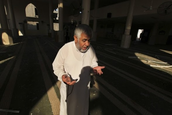 A Palestinian man prays inside the damaged Bin Zayed mosque after an Israeli air strike in Gaza