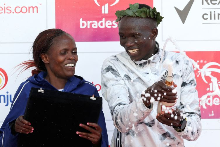 Brigid Jepchirchir Kosgei e Kibiwott Kandie do Quênia comemoram no pódio depois de vencer a corrida anual "São Silvestre"
