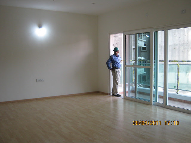 Spacious living with wooden flooring and sliding door of the balcony in Sangria Towers at Megapolis Hinjewadi Phase 3, Pune