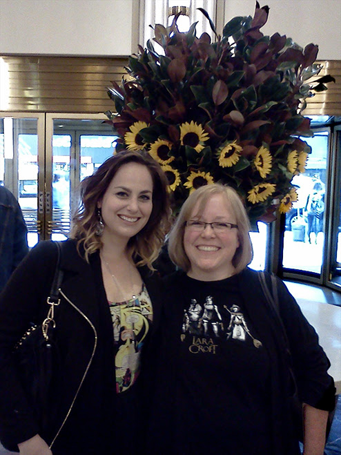 Meagan and Stella cower beneath a massive bouquet in a New York hotel lobby