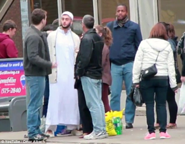 'You can't judge and stereotype people by their clothes': The scene as a middle-aged man in blue jeans and leather jacket, centre, defends the man in Muslim dress after he is accosted by the man on the right