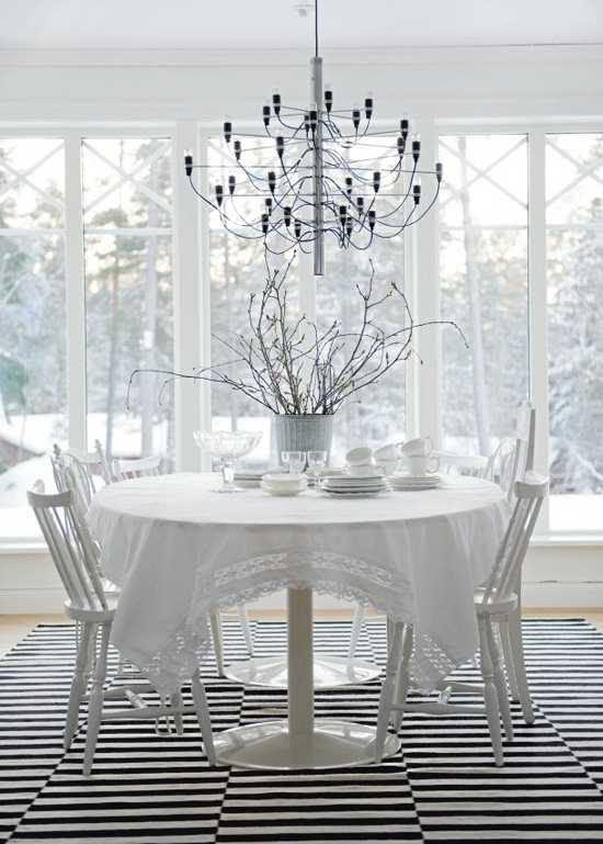 белый обеденный стол и красивая люстра
