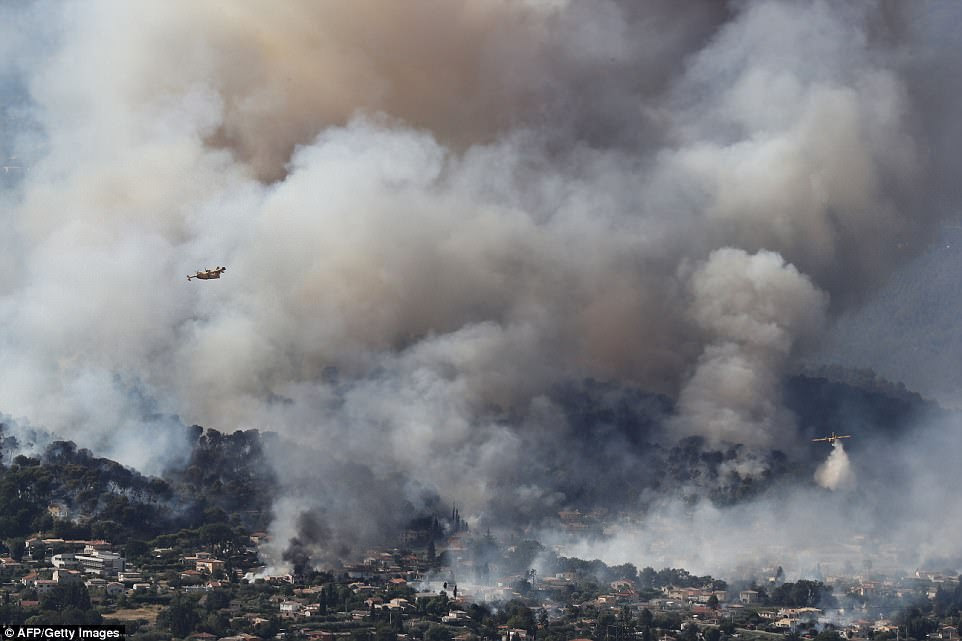 Fire fighting aircraft drop water over a fire near Carros, southeastern France on Monday. A number of fires have been causing chaos across the region