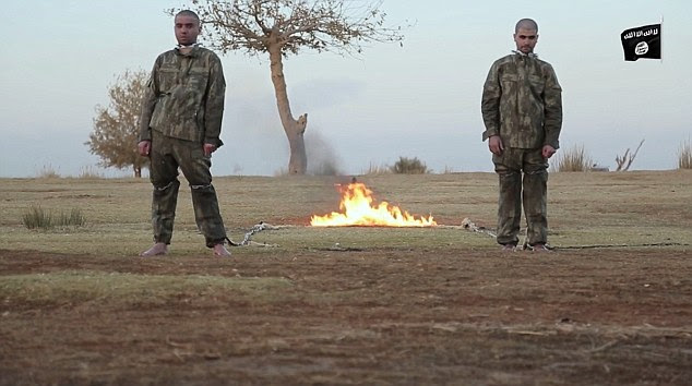 The two men are stood with their backs to the flames that will eventually kill them in a barbaric execution
