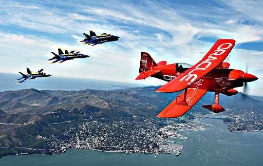 Team Oracle stunt pilot Sean Tucker flies ahead of the U.S. Navy Blue Angels as part of a practice run for Fleet Week over the bay in San Francisco, California