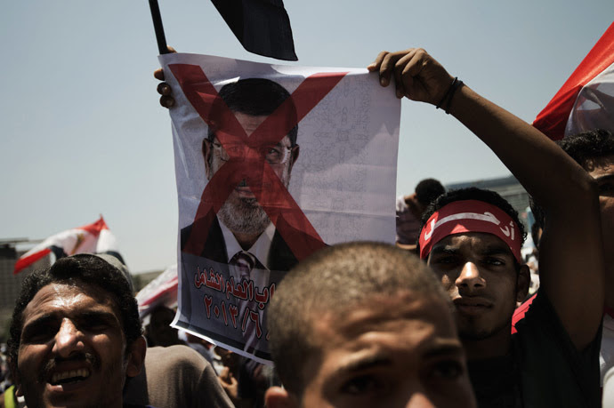 An Egyptian opposition supporter holds a crossed-out picture of President Mohammed Morsi as hundreds gather for a demonstration against Morsi and the Muslim Brotherhood in Cairo's landmark Tahrir Square on June 29, 2013. (AFP Photo)