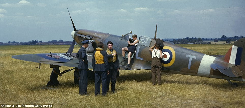 Preparing for battle: As ground crewmen inspect a Supermarine Spitfire fighter plane in a deserted field outside of London in 1941 pilots discuss their strategy for fighting in the air