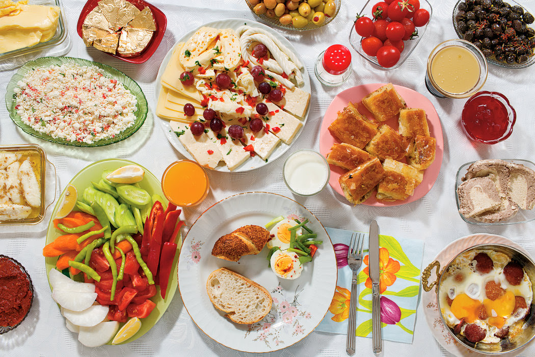 <p>The elaborate Saturday morning spread in front of Doga includes honey and clotted cream, called <em>kaymak</em>, on toasted bread; green and black olives; fried eggs with a spicy sausage called <em>sucuk</em>; butter; hard-boiled eggs; thick grape syrup (<em>pekmez</em>) with tahini on top; an assortment of sheep-, goat- and cow-milk cheeses; quince and blackberry jams; pastries and bread; tomatoes, cucumbers, white radishes and other fresh vegetables; <em>kahvaltilik</em> <em>biber salcasi</em>, a paste made of grilled red peppers; hazelnut-flavored halvah, the dense dessert; milk and orange juice. While certainly more elaborate than weekday fare, this Gursoy family meal is in keeping with the hodgepodge that is a typical Turkish breakfast.</p>