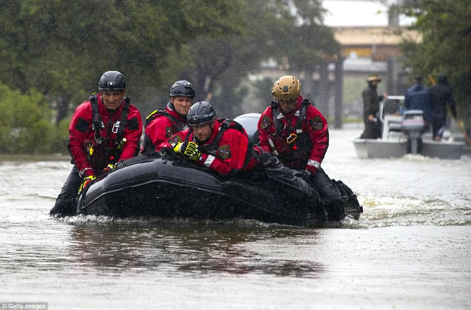 Houston Fire Department's Dive Team power through flood water in a motor boat looking for people who need to be saved